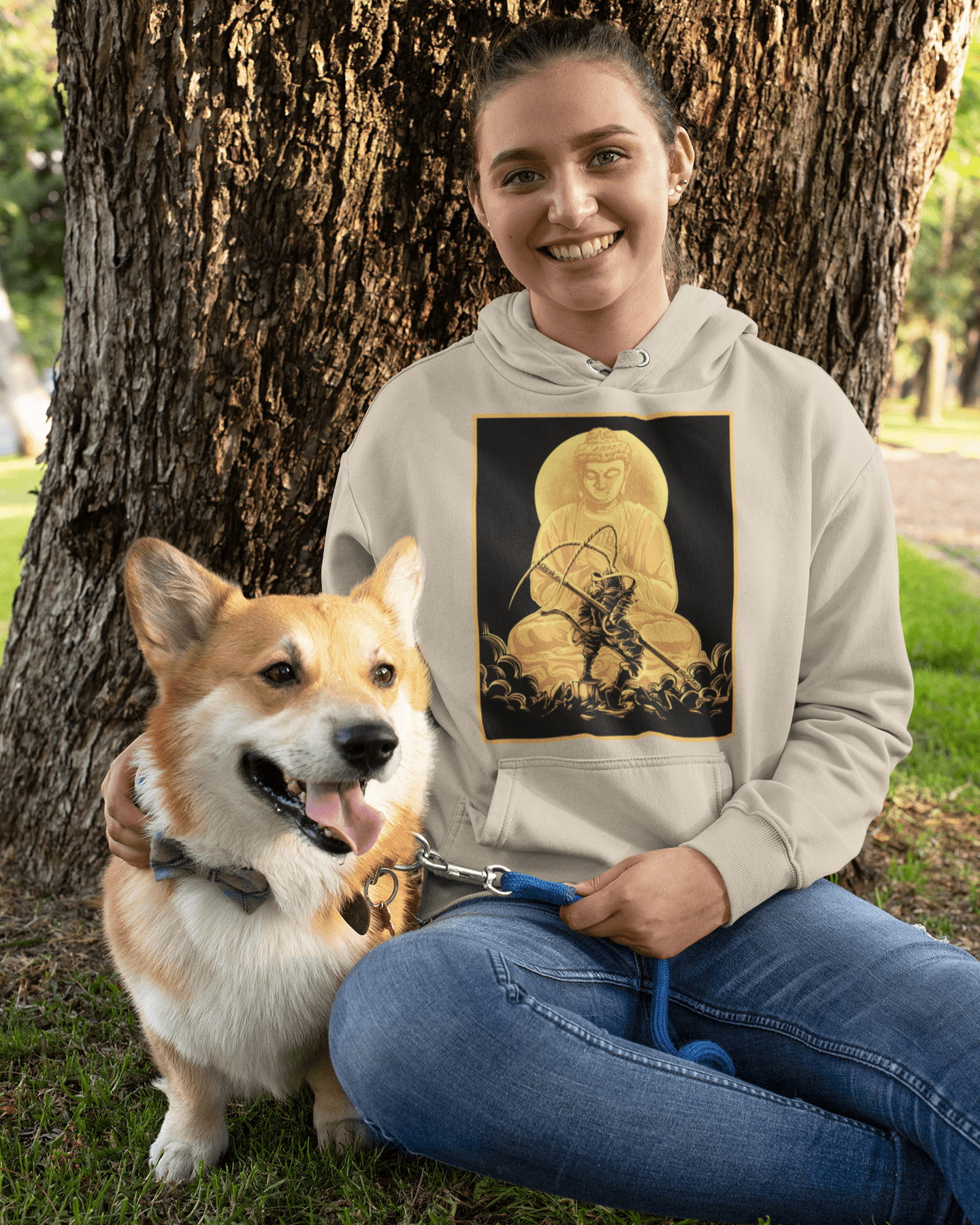 Battle-Buddha-designed-pullover-hoodie-mockup-featuring-a-woman-and-her-dog-sitting-by-a-tree