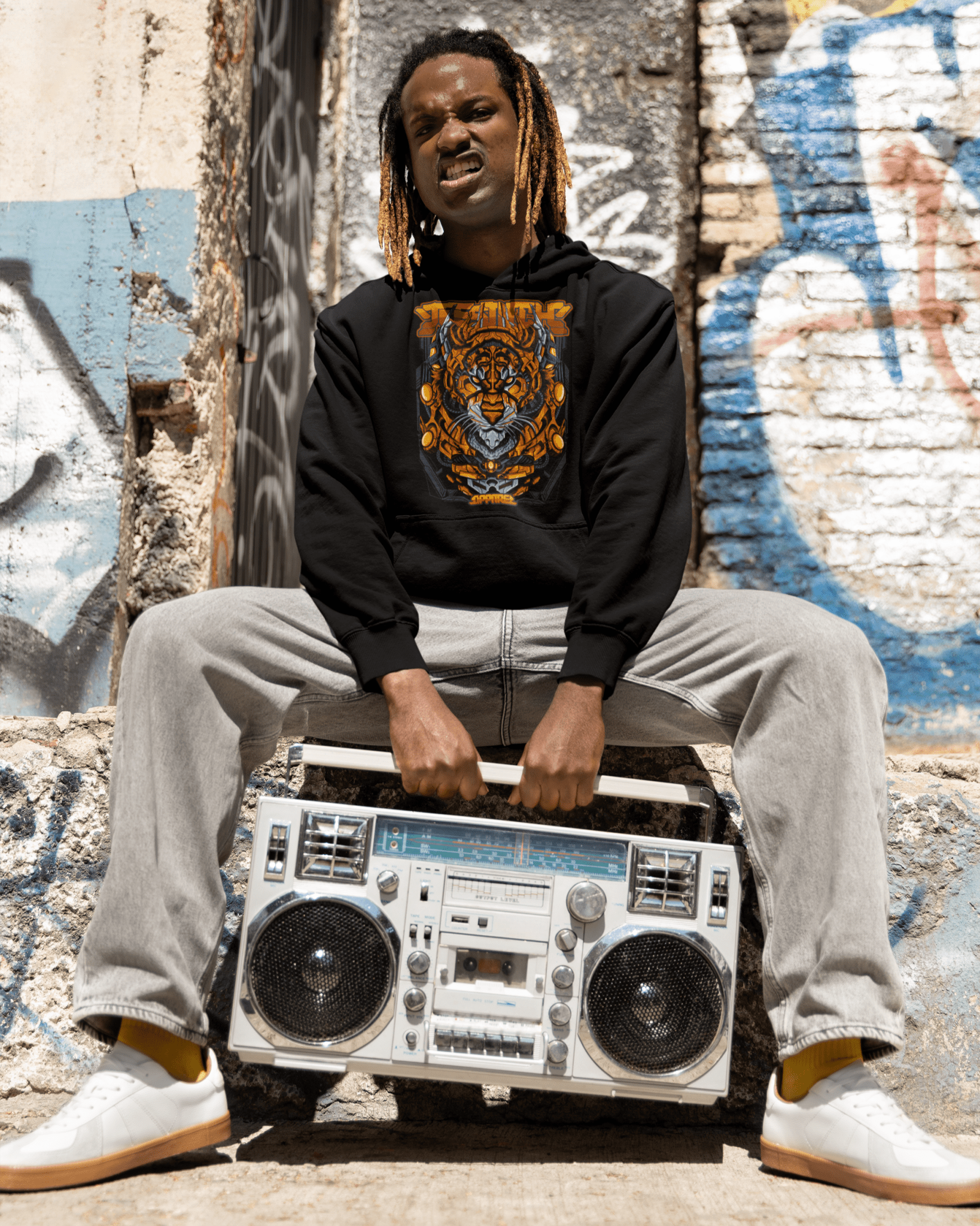 Cyger-designed-hoodie-mockup-featuring-a-man-with-a-hip-hop-style-carrying-a-vintage-stereo-teeStitch-Apparel