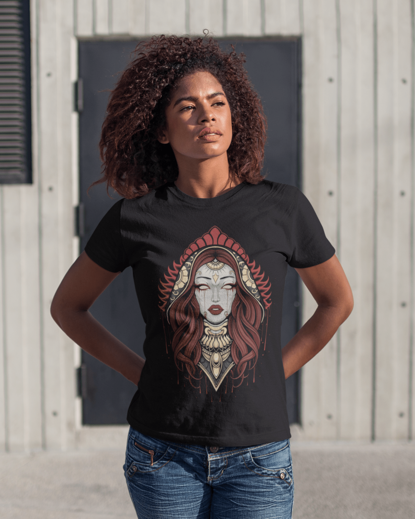 black-girl-with-curly-hair-wearing-a-tshirt-with-our-Goddess-design-while-standing-facing-the-sun