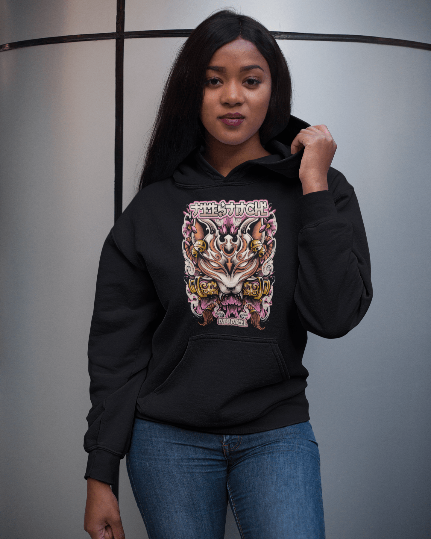 Kitsune-Mask-design-girl-holding-her-hoodie-mockup-while-standing-near-a-metal-column