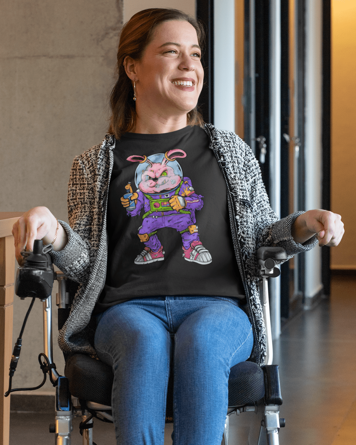 Space-_Rabbit-t-shirt-mockup-of-a-smiling-woman-using-a-wheelchair-in-a-hall