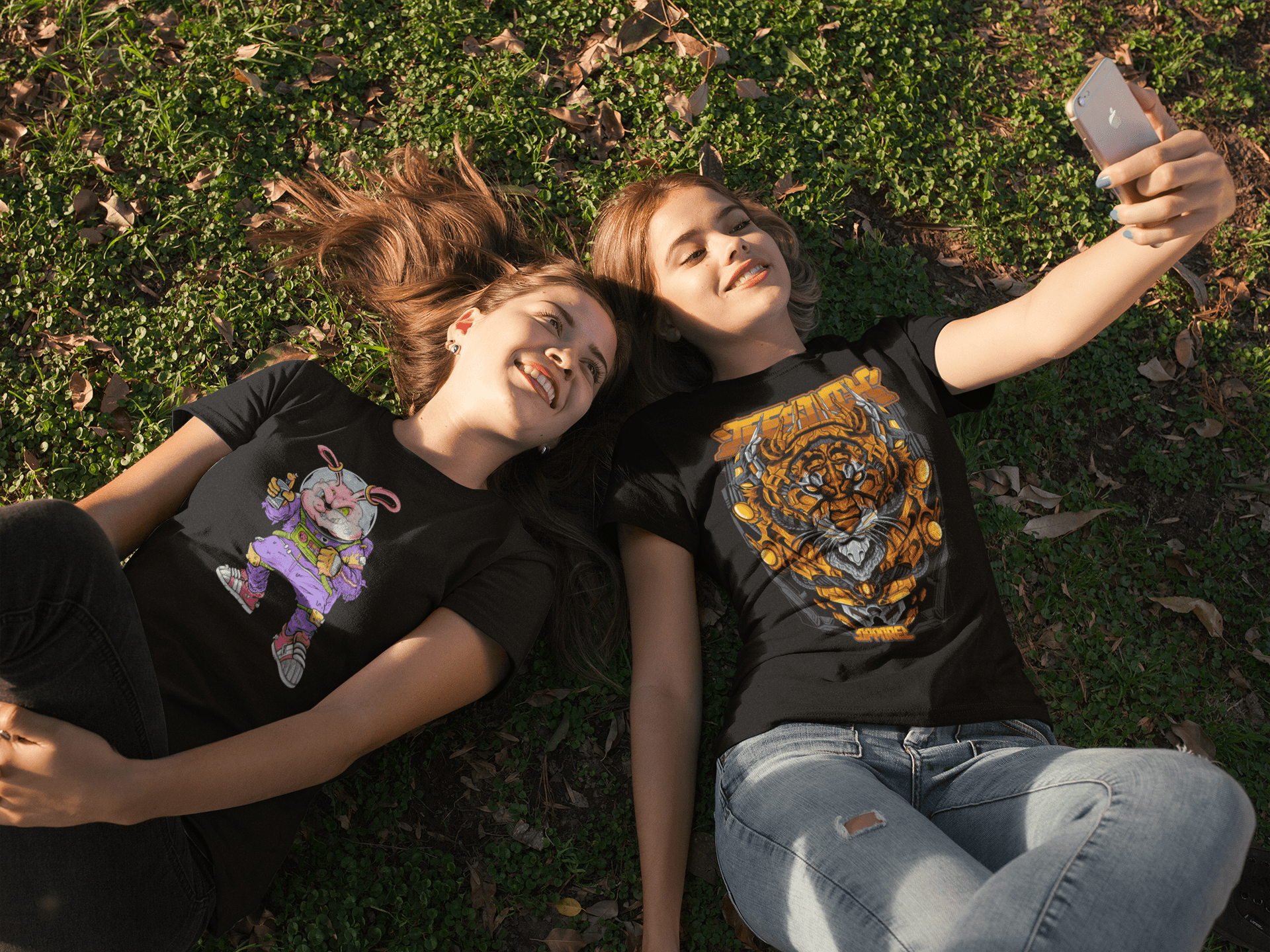 two-girlfriends-wearing-tees-mockup-while-lying-on-the-grass-taking-a-selfie