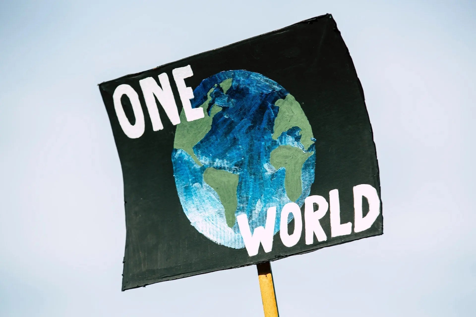 Hand-painted Earth sign with the words One World.