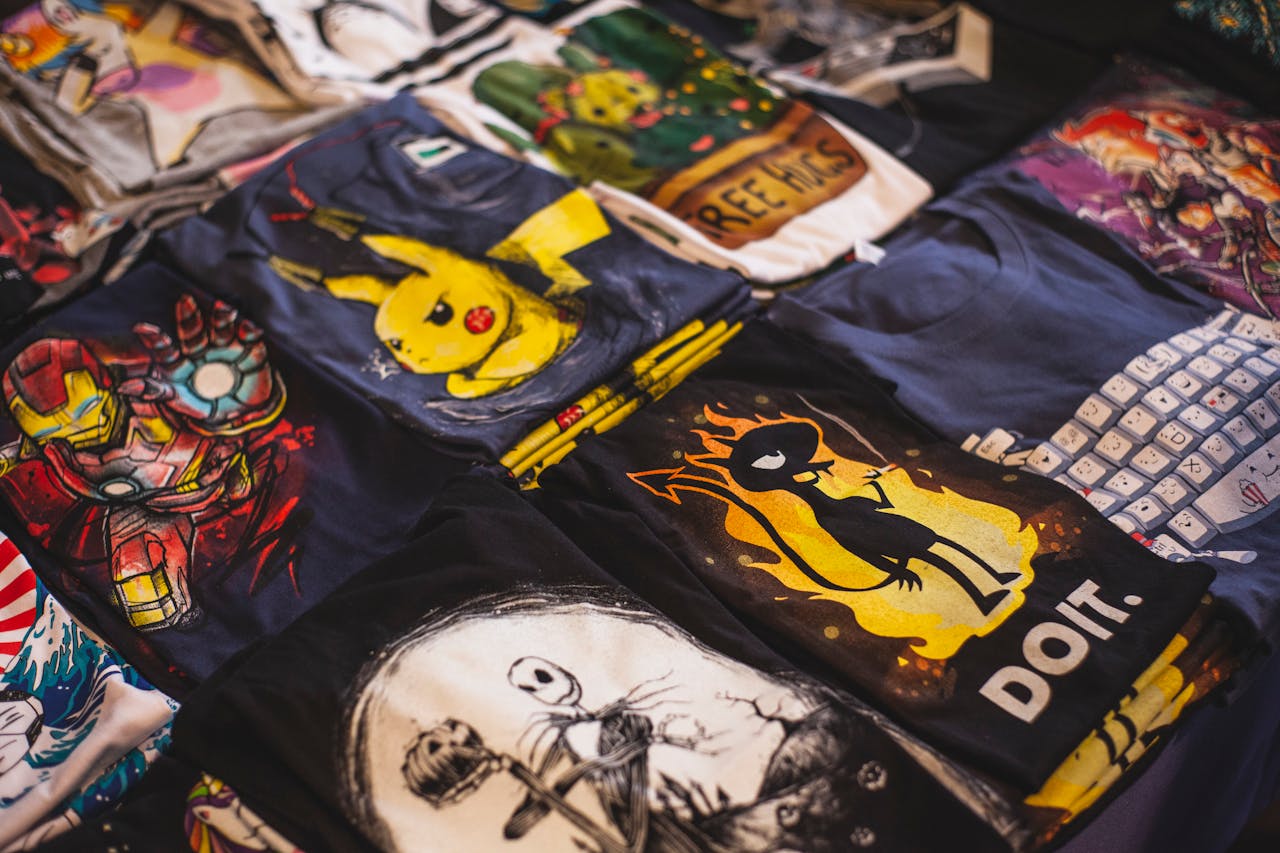 T-shirts with printed graphic designs laid out on a table.