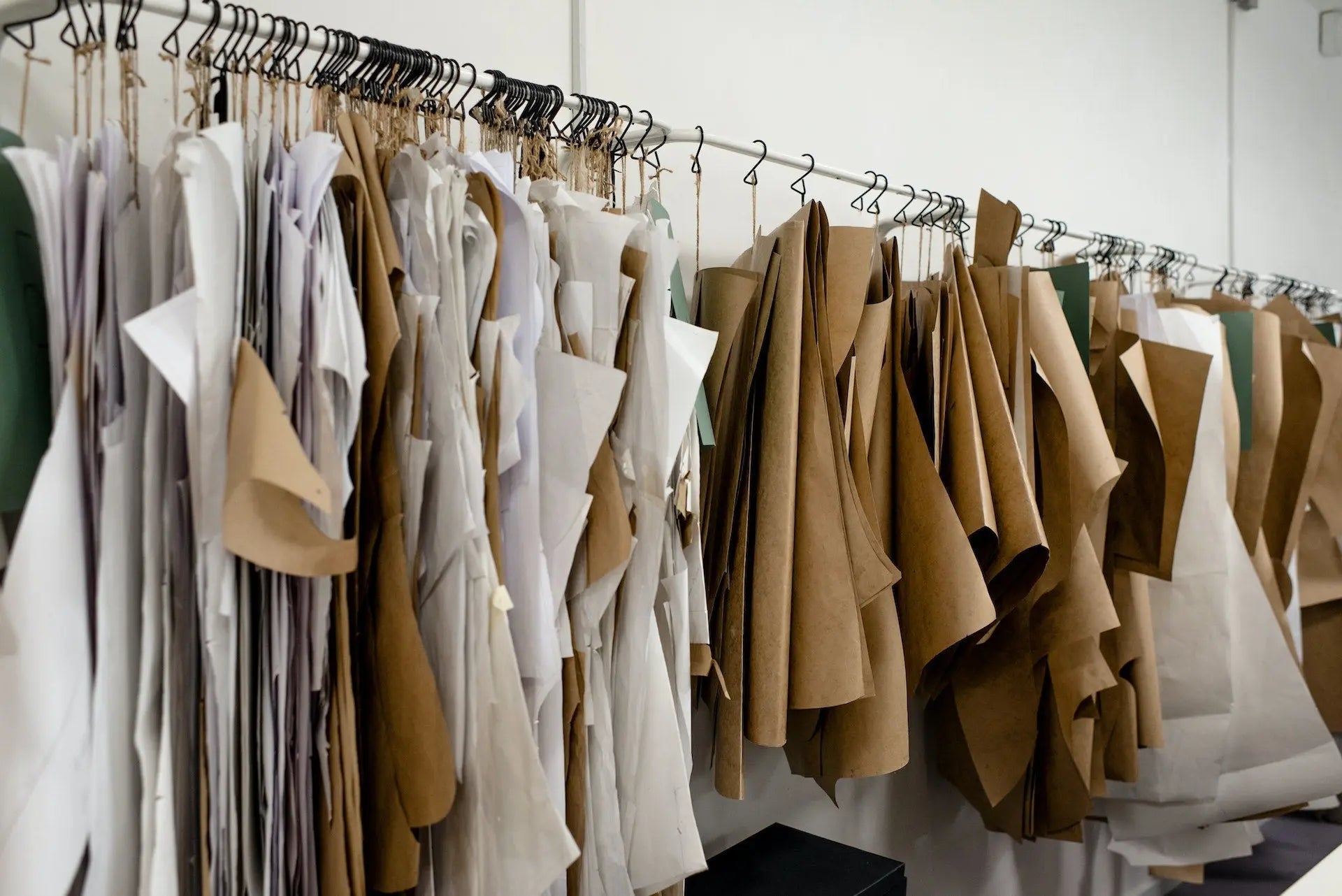 Hanging paper garment patterns in a workspace.
