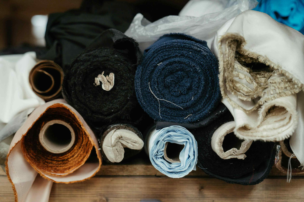 Rolled fabric bundles on a table.