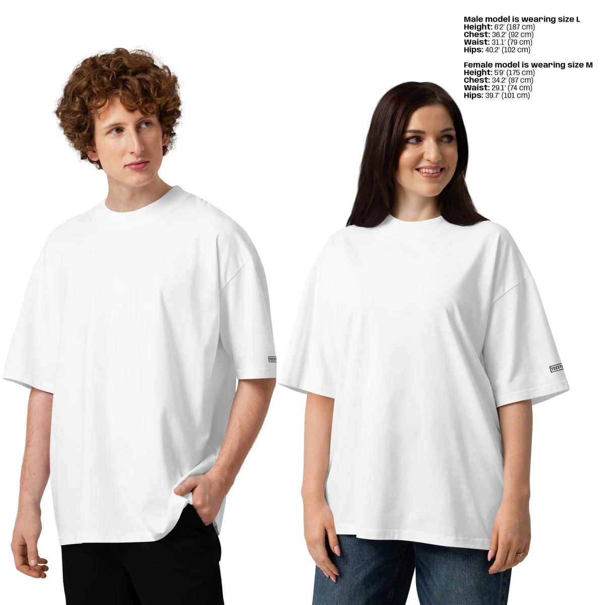 Two models wearing plain white oversized short-sleeve T-shirts against a light gray studio background, with size text printed in the upper right listing male and female measurements.