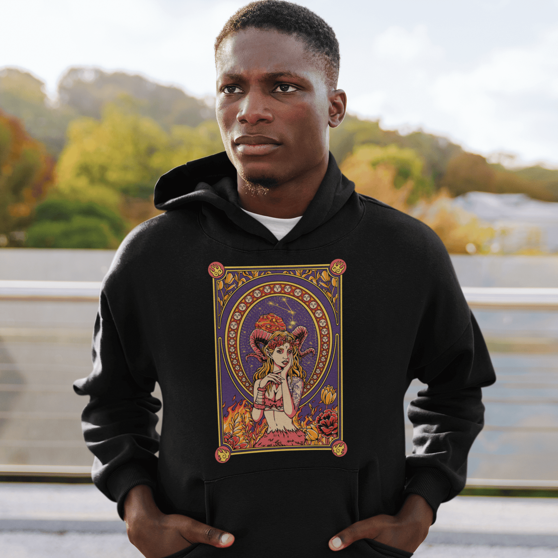 Person wearing a black hoodie with a colorful graphic design outdoors