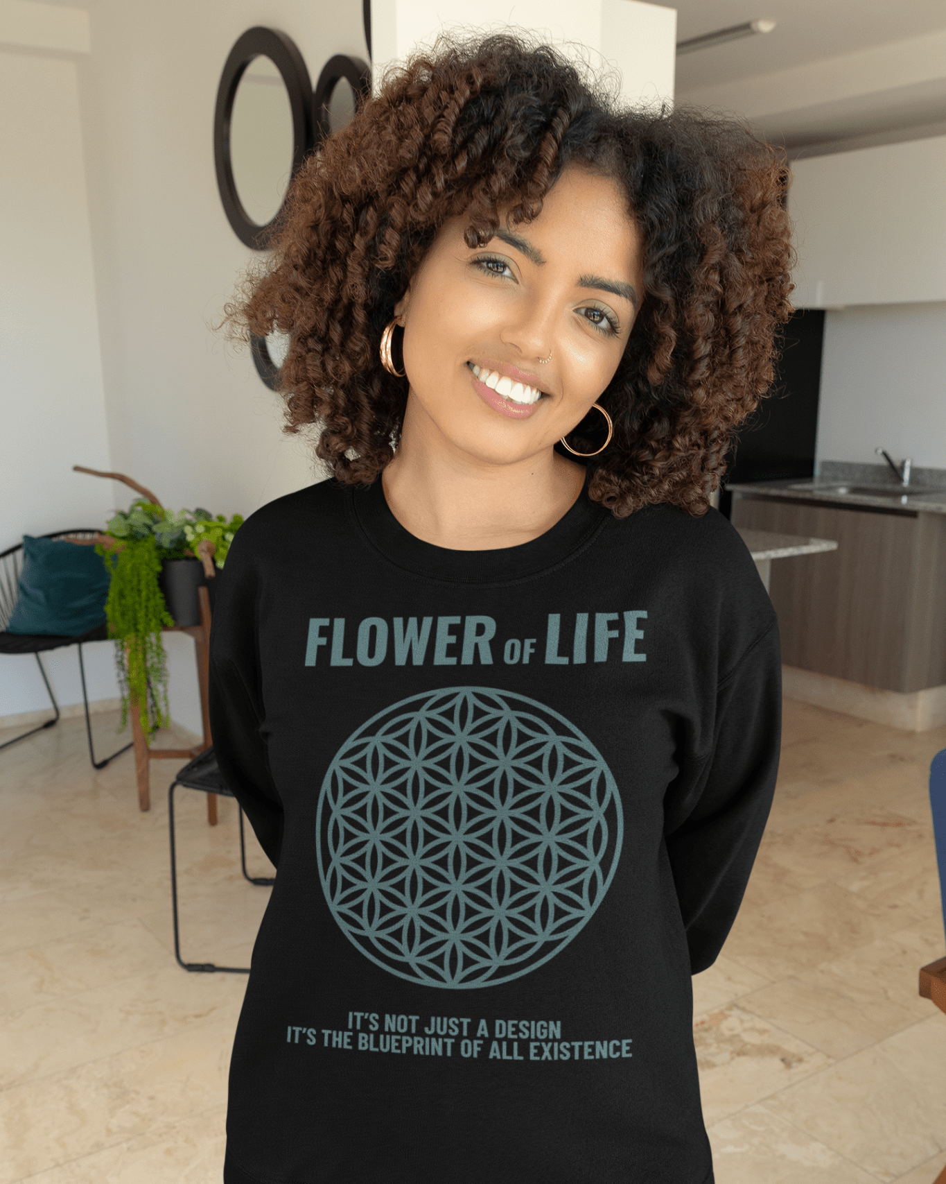 flower-of-life-mockup-of-a-woman-with-curly-hair-posing-at-home-with-a-crewneck-sweatshirt