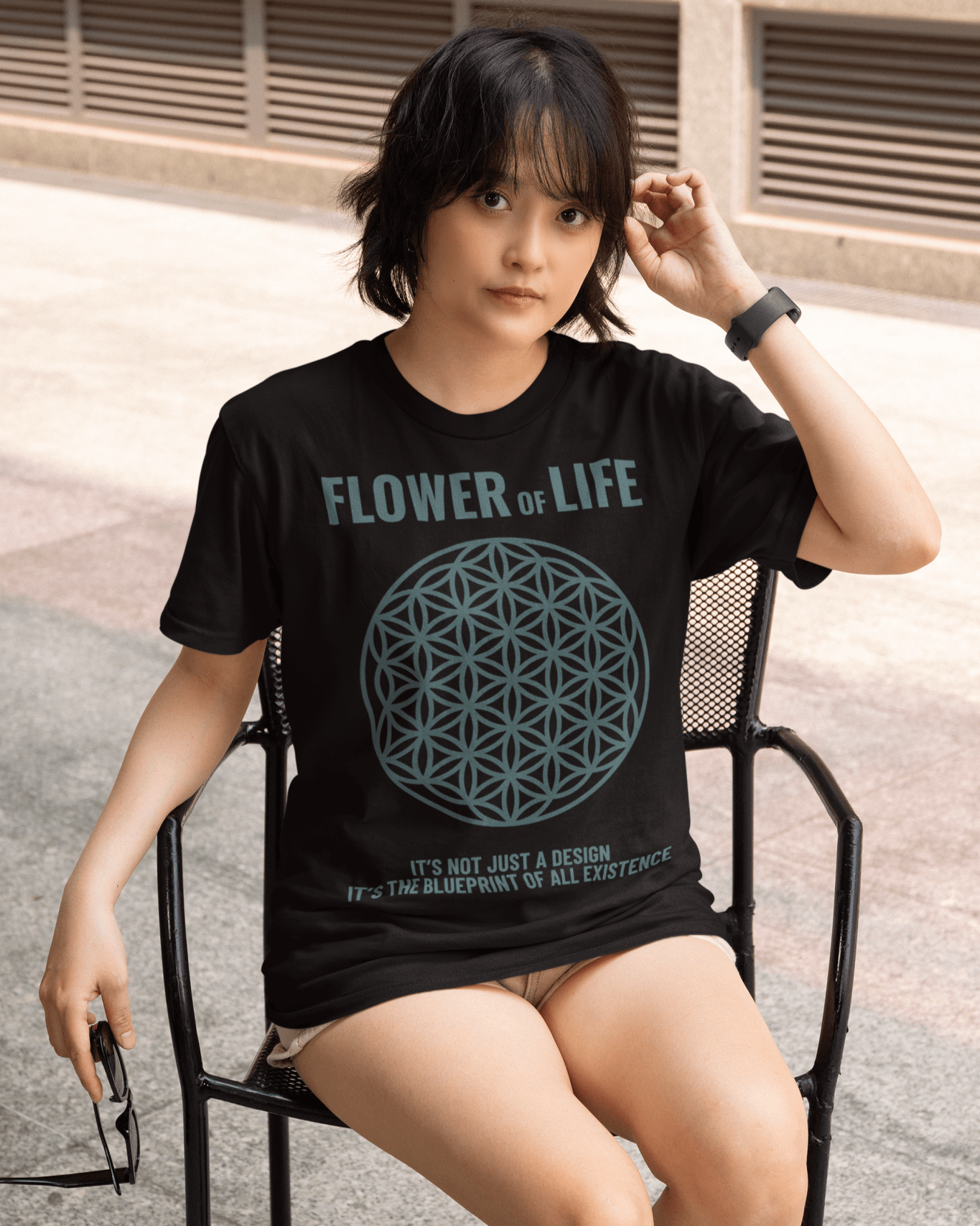 flower-of-life-t-shirt-mockup-of-a-serious-woman-sitting-on-a-chair