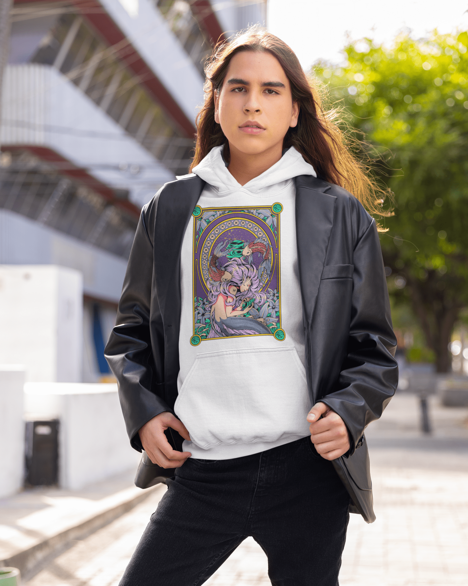 Person wearing a white hoodie with a colorful graphic design outdoors.