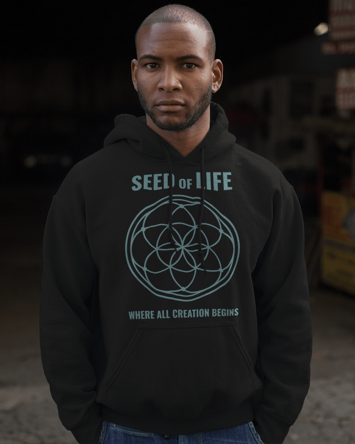seed-of-life-pullover-hoodie-mockup-of-a-young-black-man-at-a-garage